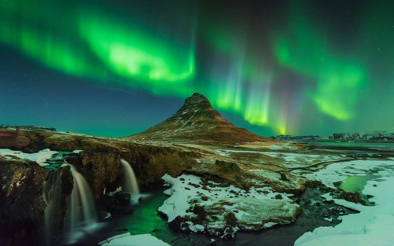 A view of the Northern Lights over an icy landscape in Iceland.