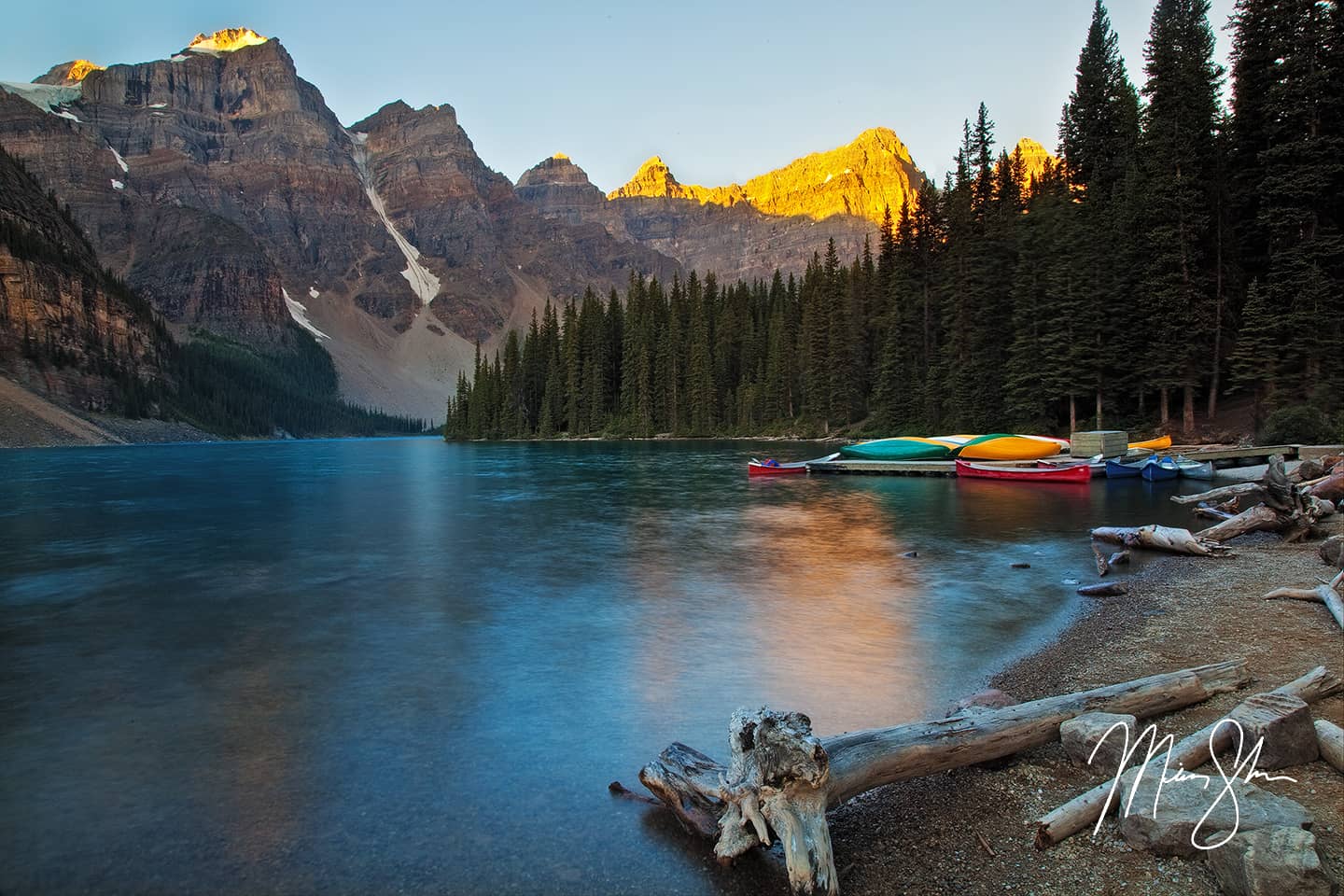 A pristine, turquoise lake surrounded by tall peaks in the Canadian Rockies.